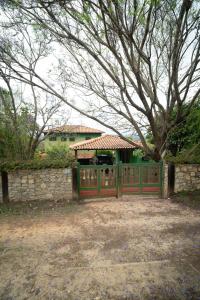 ein Tor vor einem Haus mit einem Baum in der Unterkunft Casa em Milho Verde - Minas Gerais in Sêrro