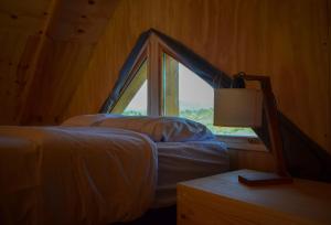 a bedroom with a bed and a window at Cabañas Altramuz in El Hoyo