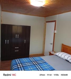 a bedroom with a bed and a dresser at Alojamiento Monitor Huáscar in Talcahuano