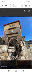 a picture of a stone building with a waterwheel at La murallita de Aroa in Cañete