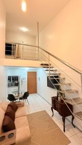 un salon avec un canapé et un escalier dans l'établissement Apartamento Vista Mar São Luís Litorânea, à São Luís