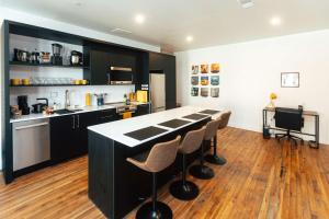 a kitchen with black cabinets and a counter with stools at Loft 302 - The William - Sunlit - Above Carrigans in Birmingham