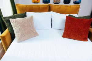 a bed with four pillows on top of it at Loft 302 - The William - Sunlit - Above Carrigans in Birmingham