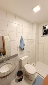 une salle de bains blanche avec toilettes et lavabo dans l'établissement Apartamento Vista Mar São Luís Litorânea, à São Luís