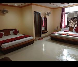 ein Schlafzimmer mit zwei Betten und einem Fenster in der Unterkunft Hotel Bharat Residency in Amritsar