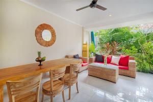 a dining room with a wooden table and chairs at Puri Canggu Villas & Rooms in Canggu