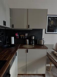 eine Küche mit weißen Schränken und Arbeitsflächen aus Holz in der Unterkunft Apartment Baltica in Rostock