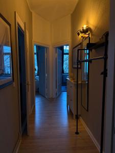 ein Flur mit gelben Wänden und Holzböden und ein Zimmer in der Unterkunft Apartment Baltica in Rostock + 6 Fotos