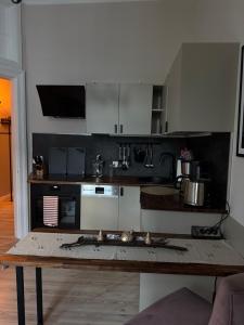 eine Küche mit weißen Schränken und einem Holztisch in der Unterkunft Apartment Baltica in Rostock