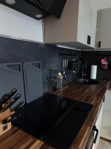 eine Küche mit schwarzen Arbeitsplatten und weißen Schränken in der Unterkunft Apartment Baltica in Rostock