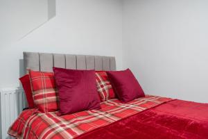 a bed with red sheets and purple pillows at Immingham Contractors stay in Immingham