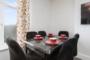 a table with four chairs and red cups on it at Immingham Contractors stay in Immingham +3 photos