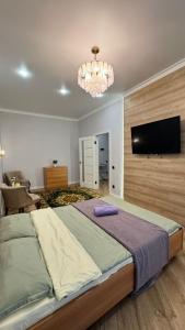 ein Schlafzimmer mit großem Bett und Flachbildfernseher in der Unterkunft Квартира на левом берегу в ЖК Alpamys A4 in Astana