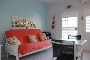 un salon avec un canapé rouge et une table dans l'établissement Casa Iliria Apartments walking distance to Boquerón, à Boqueron