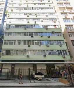 a person walking in front of a tall building at A uma quadra da praia de Copacabana in Rio de Janeiro