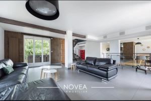 a living room with a couch and a table at L'Écrin des Greens in Dommartin