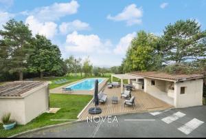 a house with a deck and a swimming pool at L'Écrin des Greens in Dommartin