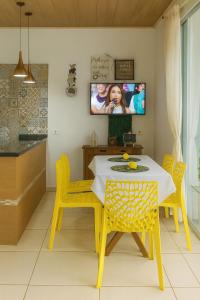 a dining room with a table and yellow chairs at Mini Garden kitnet in Paranavaí