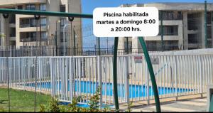 a sign on a fence near a swimming pool at Departamento Quilpué full equipado in Quilpué