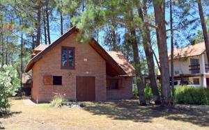 een bakstenen huis met een garage voor de bomen bij Les hirondelles in Piriápolis
