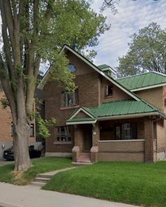 a large brick house with a green roof at La Pergola-3 in Quebec City