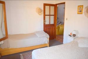 een hotelkamer met twee bedden en een deur bij Les hirondelles in Piriápolis