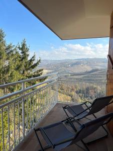 - deux chaises assises sur un balcon avec vue dans l'établissement Appartamento Le Aie, à Serralunga d'Alba
