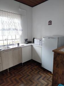 a kitchen with a white refrigerator and a window at Lori's Haus in Pomerode