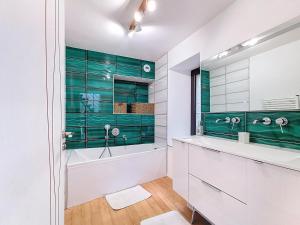 a bathroom with a tub and a green wall at Le Moulin Hochet in Les Pieux +49 photos