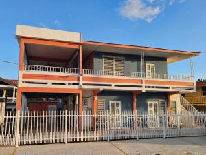 un bâtiment avec une clôture blanche devant lui dans l'établissement Casa Iliria Apartments walking distance to Boquerón, à Boqueron
