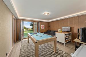 a living room with a pool table and a couch at Chalet Calin - Business & Familles in Arzier