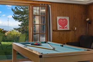 a pool table in a room with a window at Chalet Calin - Business & Familles in Arzier