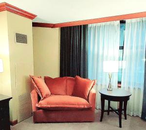 a living room with a red couch and a table at Dav's Slopeside King Studio -- Resort & Spa at Everline in Olympic Valley