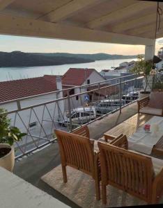 a balcony with tables and chairs and a view of a marina at Vila Mari in Tisno