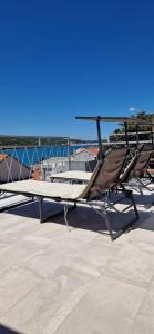 a bed and a chair on the deck of a boat at Vila Mari in Tisno