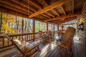 a screened in porch with rocking chairs and a table at Merlot Chateau - Views, New Hot Tub, Fire Pit, Game Room, Wi-Fi - Mins to Blue Ridge in Morganton