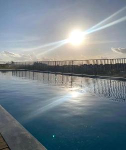a pool of water in front of a fence at Apartamento com piscina, terraço, churrasqueira e estacionamento in Pelotas