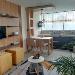 un salon avec une table et des chaises et une cuisine dans l'établissement Comfortable departamento de 2 habitacones en la Victoria con garaje gratis, à Ibarra