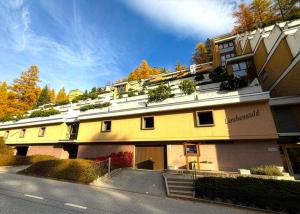 a yellow building with plants on the top of it at Retro Alpine Studio - Terrace with Mountain View in Leukerbad