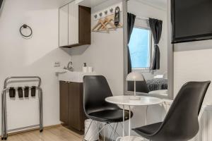 a small kitchen with black chairs and a table at Flyers Airport Hotel in Keflavík
