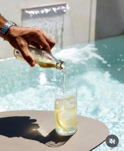 a person pouring a fish from a bottle into a glass at Suite Capurso Bari jacuzzi e parking in Capurso