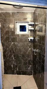 een badkamer met een zwarte marmeren muur met een raam bij Le Berkane in Argenteuil