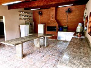 eine Küche mit Tisch und zwei Kühlschränken in der Unterkunft Chácara do Zizi in Elias Fausto + 9 Fotos