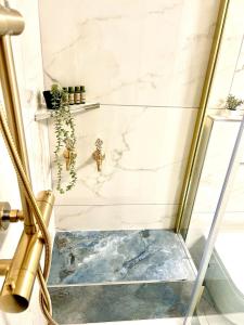 a glass shower in a bathroom with a marble wall at Ferienwohnung mit Free Parking in Romanshorn