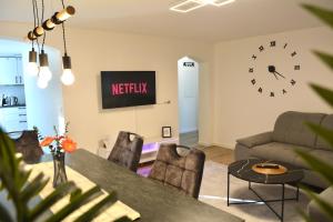 a living room with a table and a clock on the wall at Luxuswohnung in Bodensee, im Radweg mit Parkplatz in Romanshorn