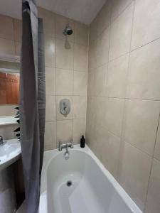 ein Badezimmer mit Badewanne und Waschbecken in der Unterkunft Nexus - Top Floor City Views, Balcony & Parking in Birmingham + 7 Fotos