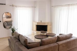 a living room with a couch and two tables at Afroditi's Apartment Superb View in Gythio