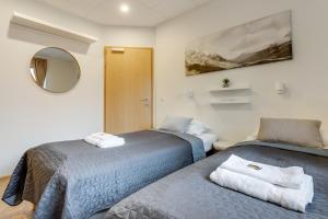 a bedroom with two beds and a mirror at Flyers Airport Hotel in Keflavík
