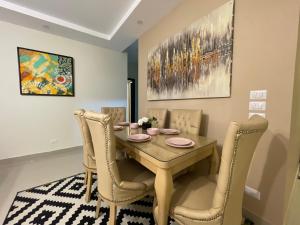 a dining room with a wooden table and chairs at Modern apartment with garden in Sheikh Zayed