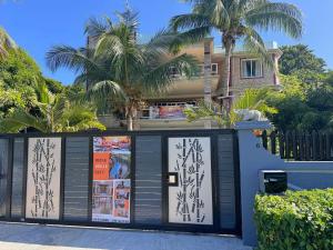 a house with palm trees behind a building at Soleil Vacances Bed and Breakfast in Flic-en-Flac